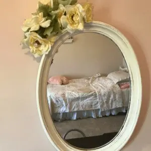  Mirror with flowers at the top of it.