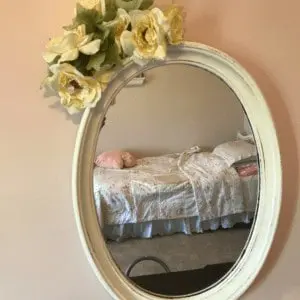 Mirror with flowers at the top of it.