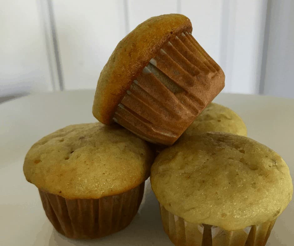 Four mini banana muffins on a white plate. 