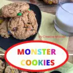 Monster cookies on a grey plate with milk next to it with more cookies on a cooling rack. The words Monster Cookies are in an oval in the middle of the image.