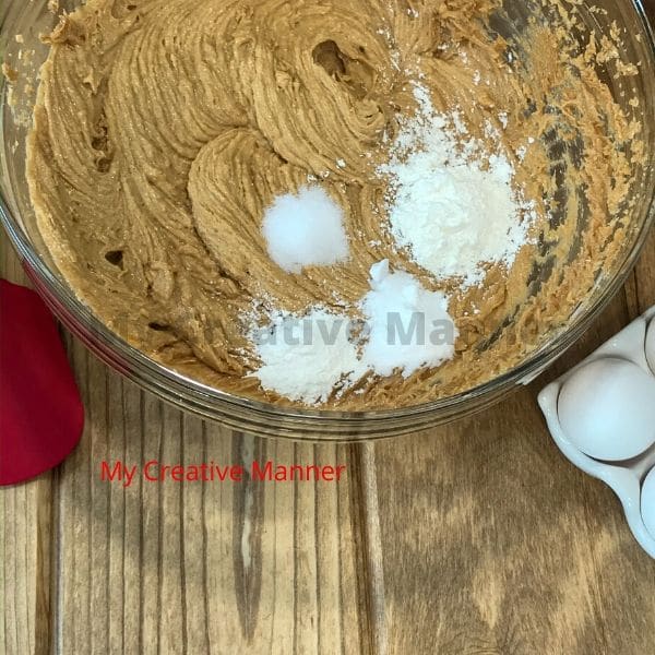 Baking soda, cornstarch, and salt being added into the batter for these big cookies.