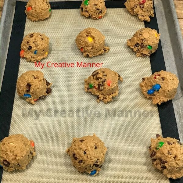 The monster cookies placed on a cookie sheet before they are baked.