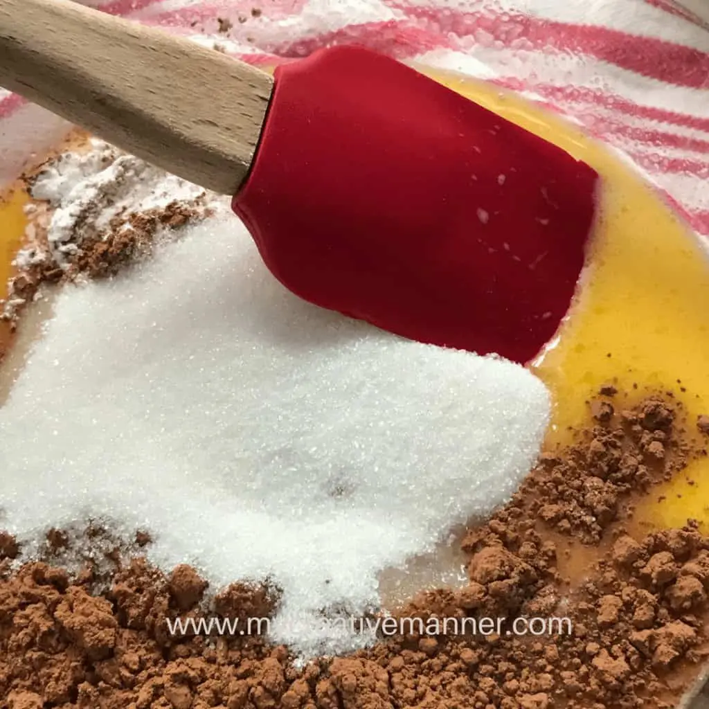 Th ebatter for a chocolate crockpot cake being mixed together in a bowl.