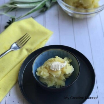 Bowl with mashed potatoes in it and a yellow napkin next to it with a fork on it.