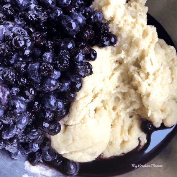 Batter and blueberries on a mixing bowl.