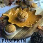 Wood tray with pumpkin muffins on it and leaves and a pumpkin around the wood tray.