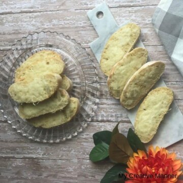 Garlic Cheese Toast on a glass platter and on a marble board with a flower in the corner of the picture.