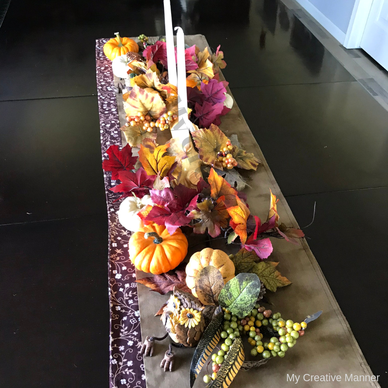 Table with a center piece that is fall theme.