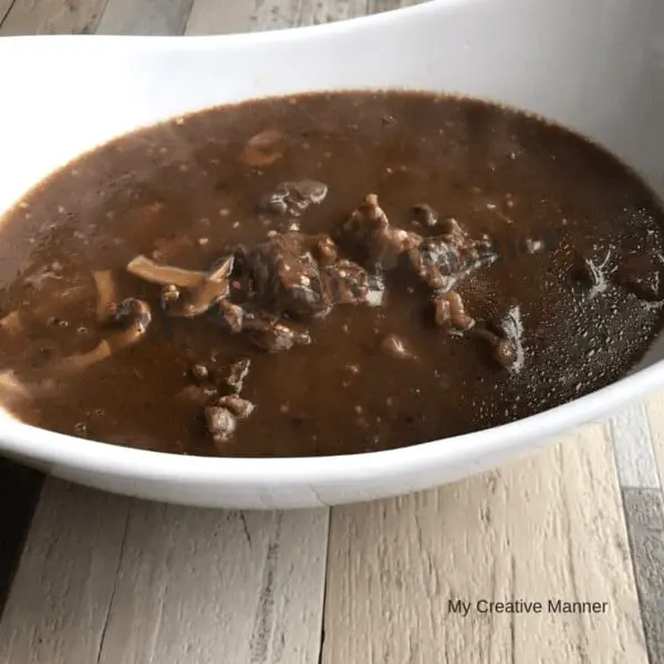 Instant pot beef tips in a white bowl.