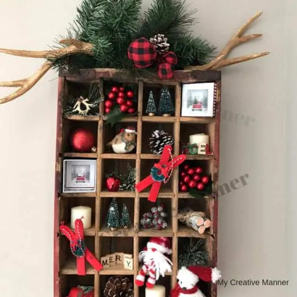 Antique Coke crate that is filled with many small Christmas decorations.