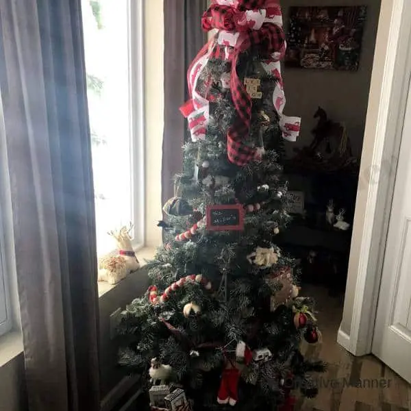 Rustic Christmas Tree with a large bow on top of the tree.