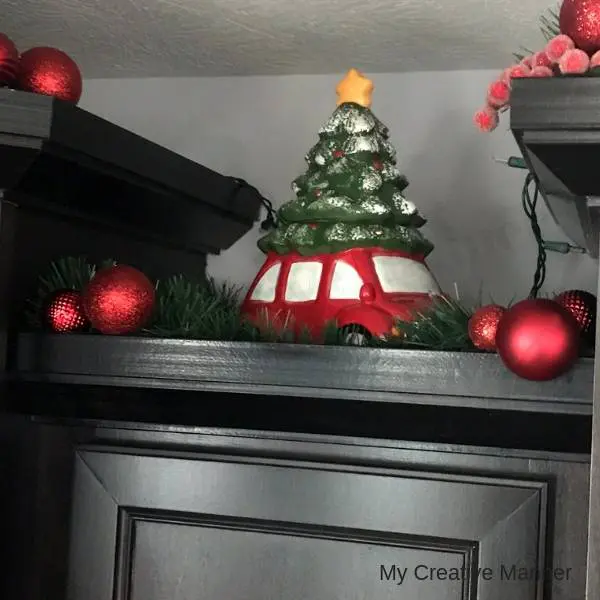 Christmas Cookie Jars with green garland and red ornaments around it.