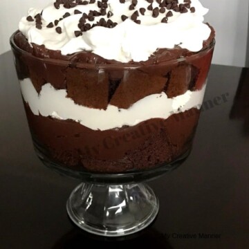 Trifle bowl that is layered with chocolate cake, chocolate pudding, and cool whip.