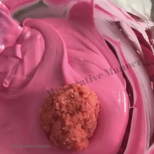 Cake pops being dipped into melted chocolate.