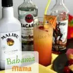 Tall glass filled Bahama Mama Cocktail with a bottle of malibu rum, bacardi rum, and captain morgan rum next to it.
