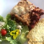 A plate with easy lasagna, garlic toast, and a fresh salad
