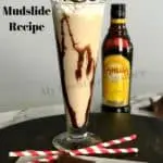 Tall glass filled with a Frozen Mudslide with a bottle of kahlua behind it.