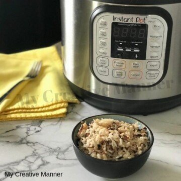 Instant Pot with a yellow napkin that has a fork on it. A small grey bowl that has wild rice in it.