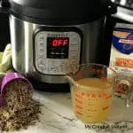 Instant Pot with a measuring cup of rice spilling our of it. Another measuring cup with chicken broth in it. And the words How to make wild rice in an instant pot.