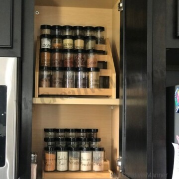 Picture of a cupboard with two shelves that have spice racks on them. Each spice rack is filled with spices.