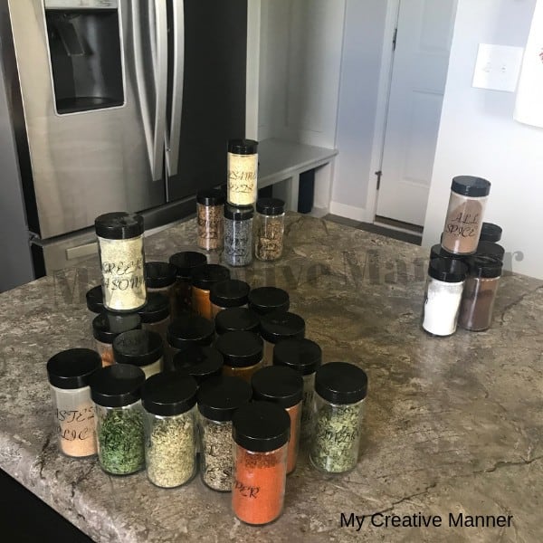 Spices sitting on a counter top that is sorted into groups.