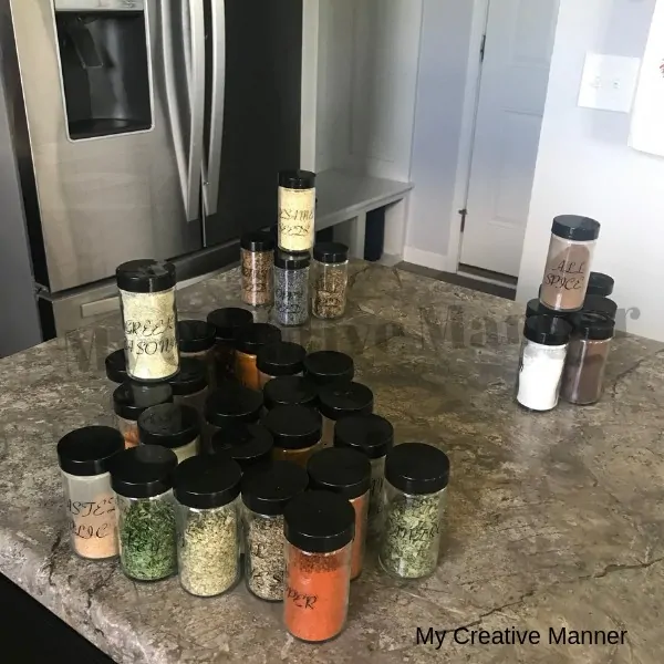 Spices sitting on a counter top that is sorted into groups.