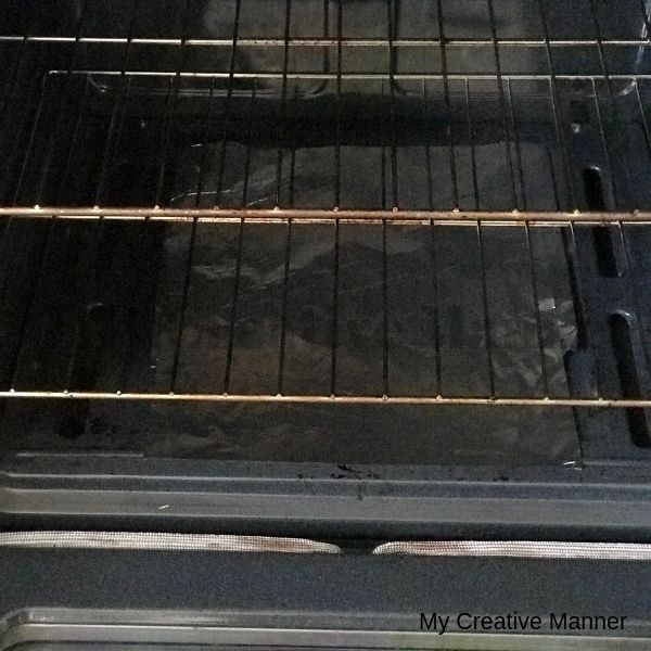 Inside an oven that has foil on the bottom of the oven.