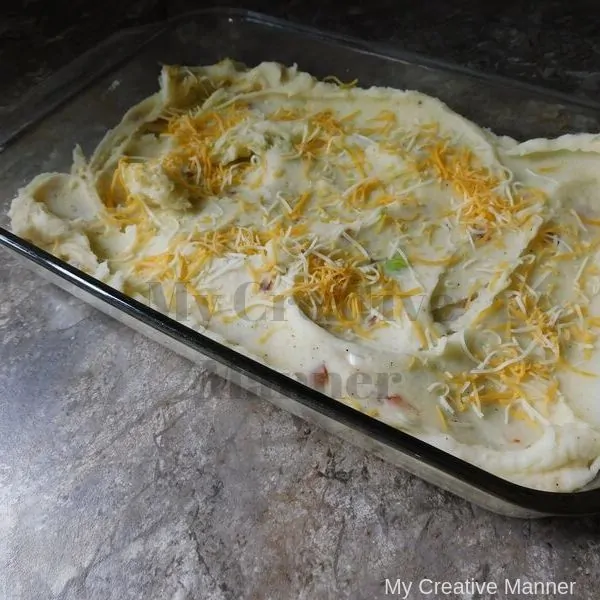 Baking dish with loaded mashed potatoes that haven't been baked yet.