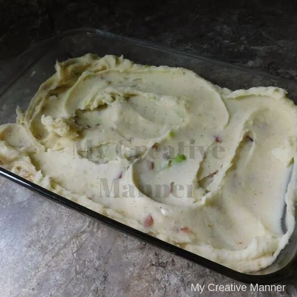 Uncooked loaded mashed potatoes that are in a baking dish.