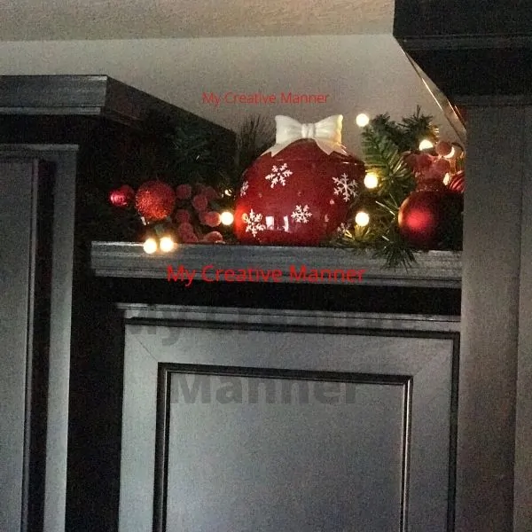 Top of a cupboard that has a cookie jar on it.