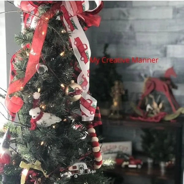 A large bow on top of an rustic Christmas tree.