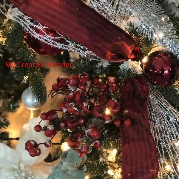 Close up of red and silver ribbon and cranberry picks that are Christmas decor ideas. 