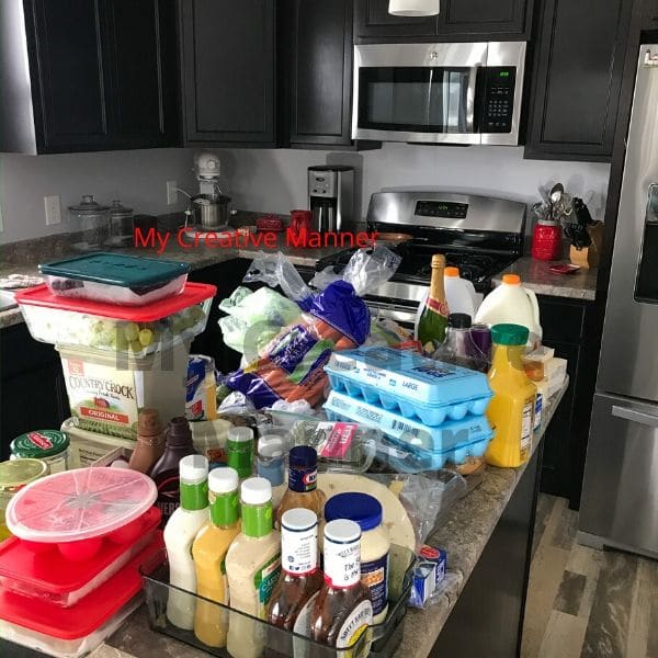 A counter top that is full of things that belong in the fridge before it was organized.