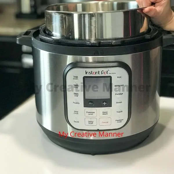 The front of an Instant Pot with the Inner pot being lifted out.