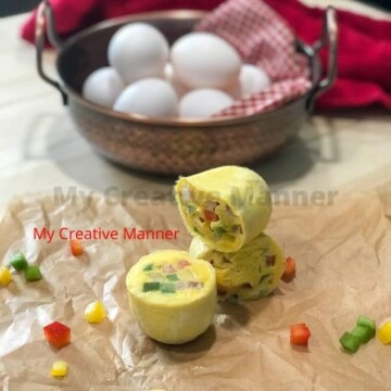 Three eggs bites on wax paper with a bowl filled with eggs behind it.