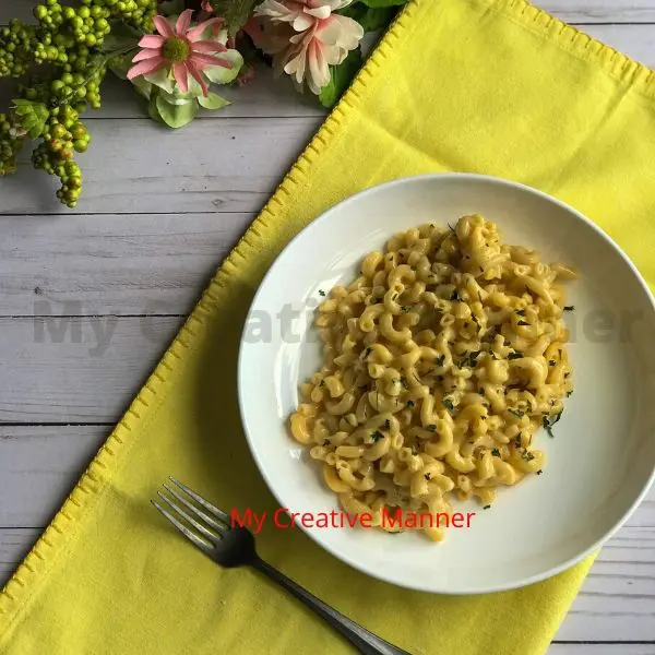 Macaroni and cheese in a bowl that is on a yellow napkin.