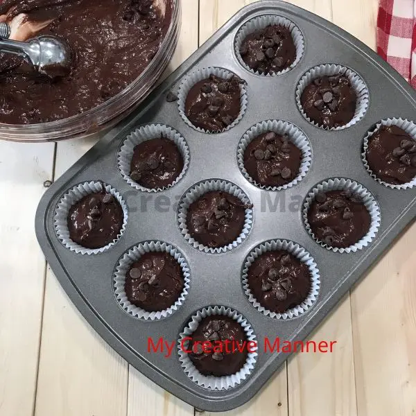 Muffin tin that is filled with batter and a bowl with the rest of the batter.