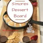 S'mores dessert board with strawberries, chocolate, and cookies.