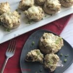 Mushrooms on a black plate with more on a white plate.
