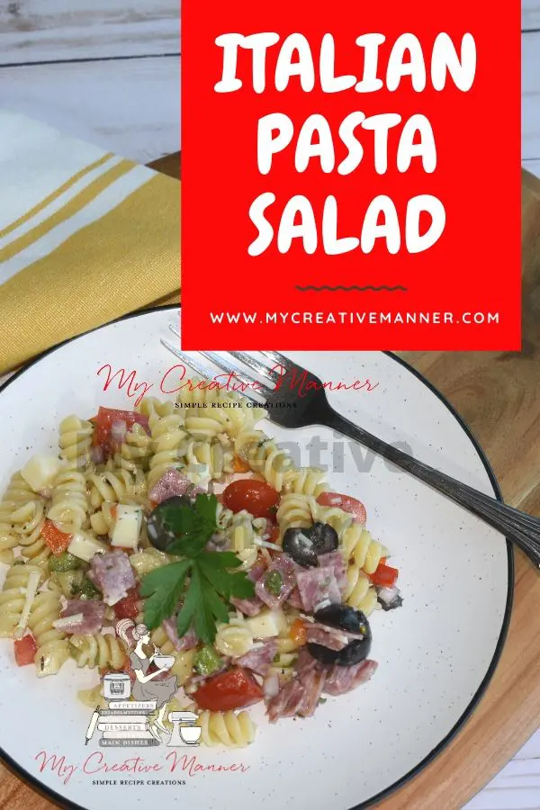 White plate with pasta salad and a fork on it.