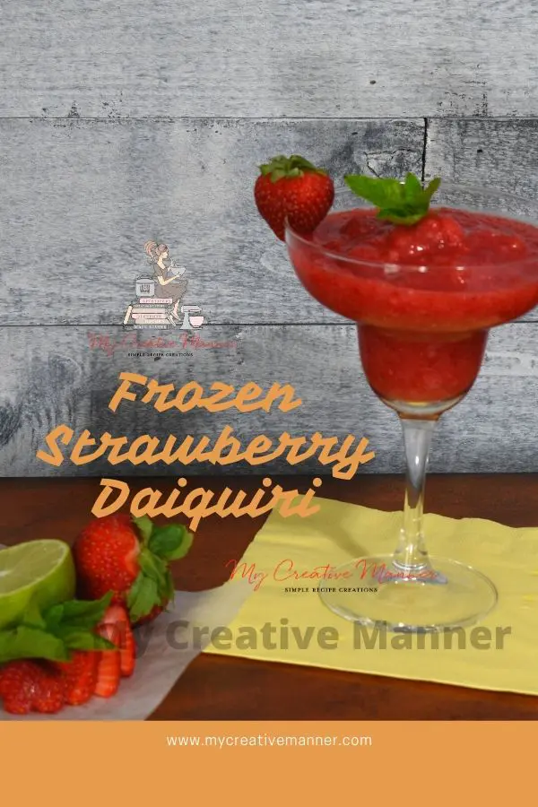 Strawberry Daiquiri in a glass that's on a yellow napkin with fresh strawberries next to the glass.