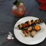 Grilled chicken Kabobs with vegetables on a white plate.
