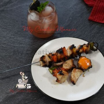 Grilled chicken Kabobs with vegetables on a white plate.