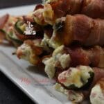 Stuffed peppers stacked on a white plater.