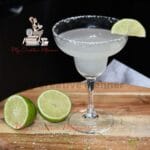 Classic Margarita in a glass with limes next to it.