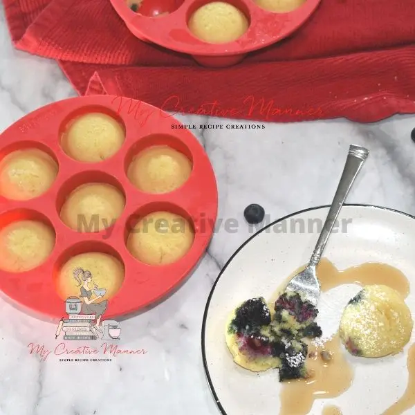 Blueberry pancake bite on a plate with more in a mold next to it.