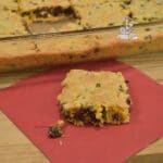 A close up of a cookie cake bar on a napkin.