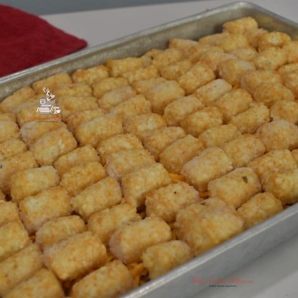Tater tots all lined up in a baking dish for tater tot casserole recipe.