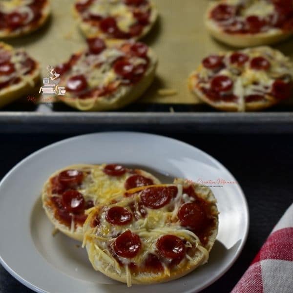 Pizza bagel bites on a plate and on a sheet pan.