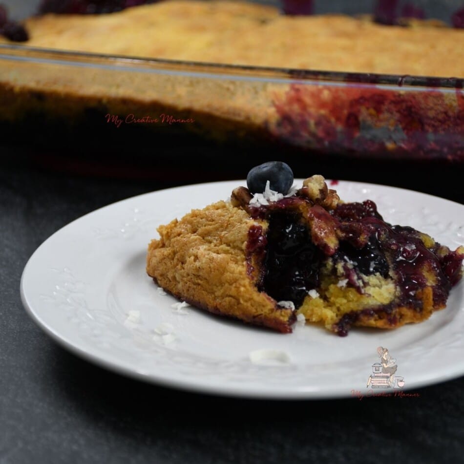 A close up of the blueberry dump cake that is on a white plate.